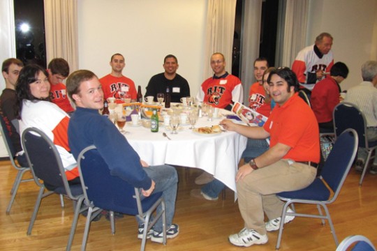 People posing for camera at a banquet table.