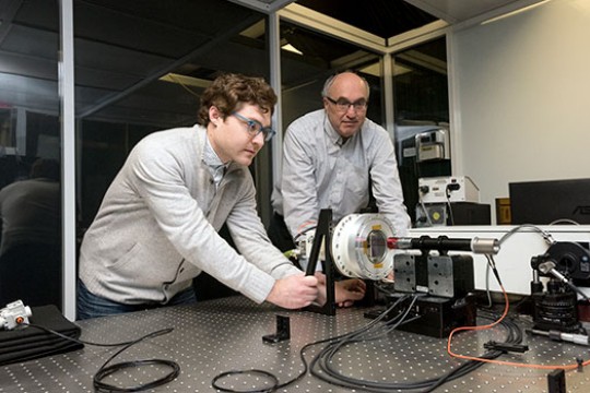 Two people working on a astronomical imaging system.