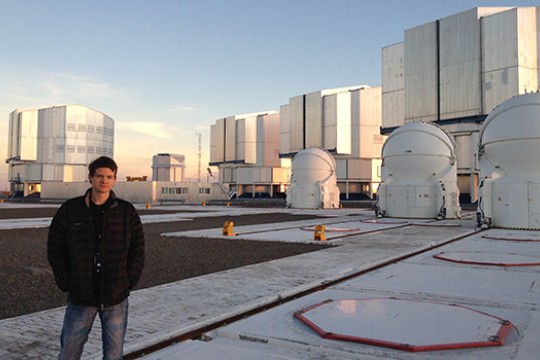 Person posing in field with multiple observatories