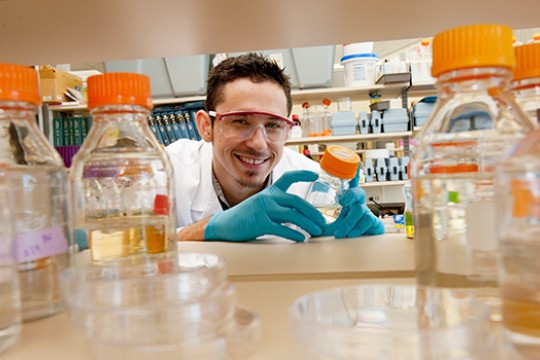 Scientist posing with bottle in lab