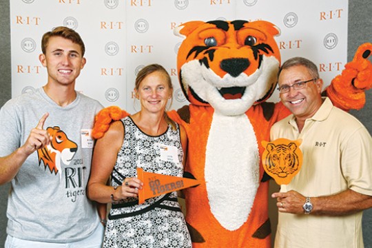 parents and son posing with Tiger mascot.