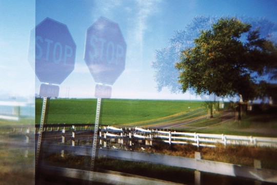 Blurry photo of stop sign and fence.