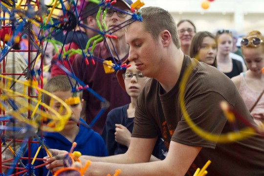 Student works on amusement park ride make of K'nex pieces.
