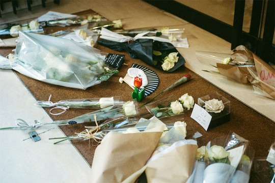 flowers and mementos on floor near doors.