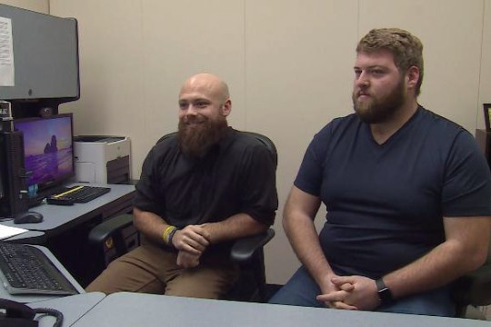 two men sitting at desk.