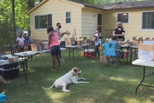 people assembling giftbags in a backyard.
