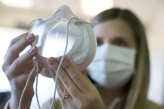 woman holding up a clear face mask.