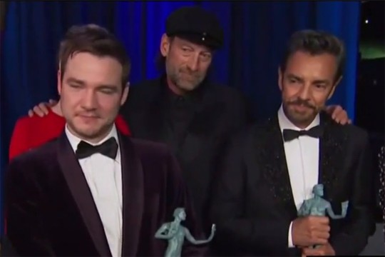 three actors receiving an award.