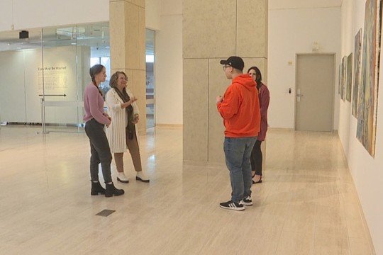 four people talking in an art gallery.
