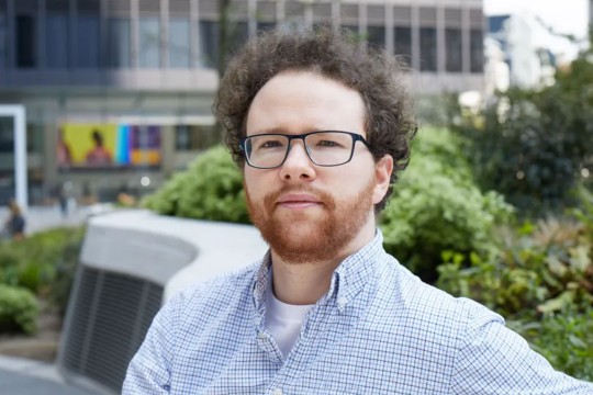 Gabriel Isserlis sitting outside on a bench.