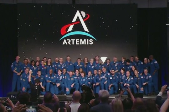 a group of astronauts posing on a stage.