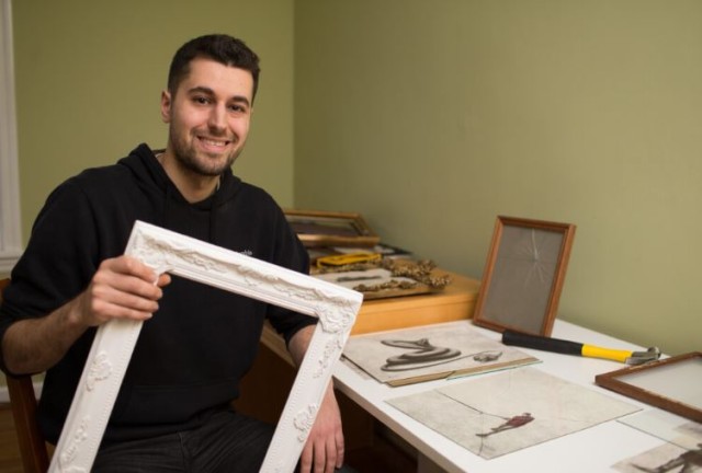 andrew scott posing with his drawings