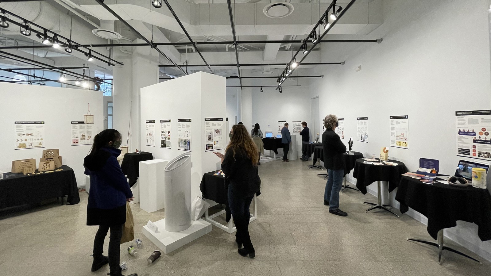 Gallery visitors look at designs displayed in RIT City Art Space.