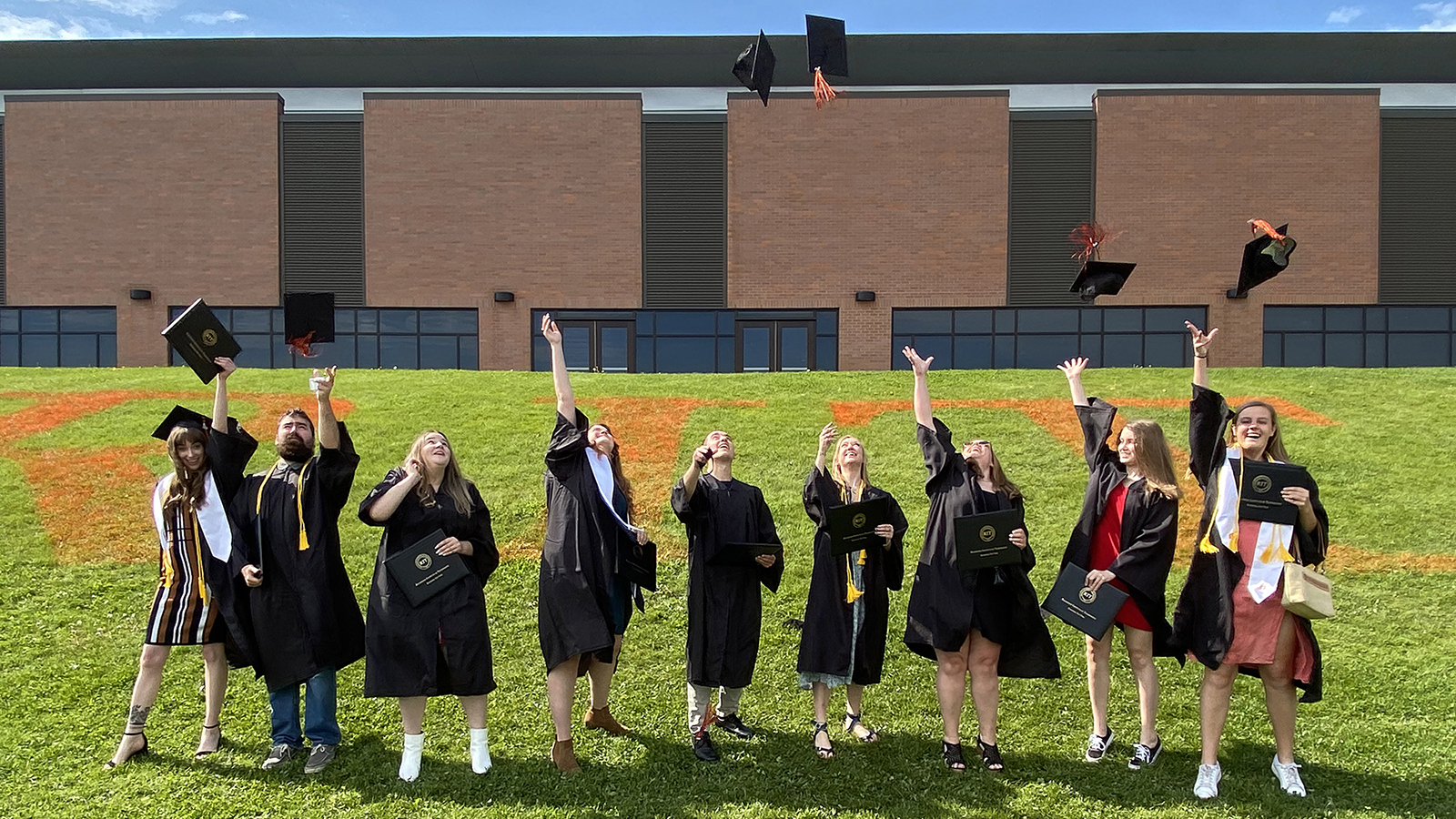 A group of students throw their graduation caps in the air.