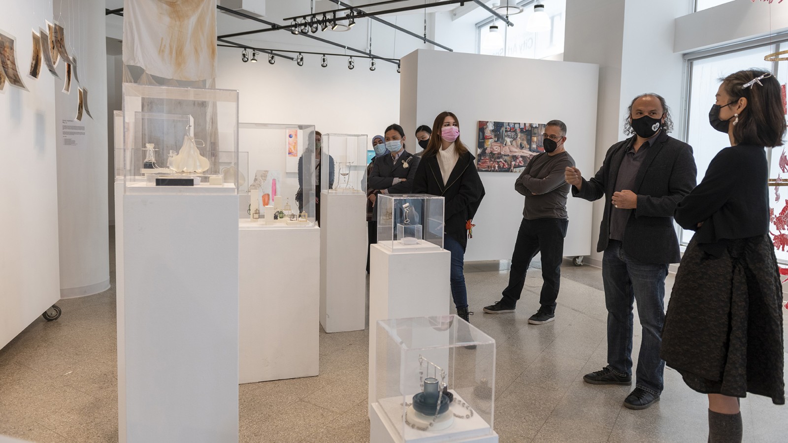Students and faculty gather around a display of work during a critique.