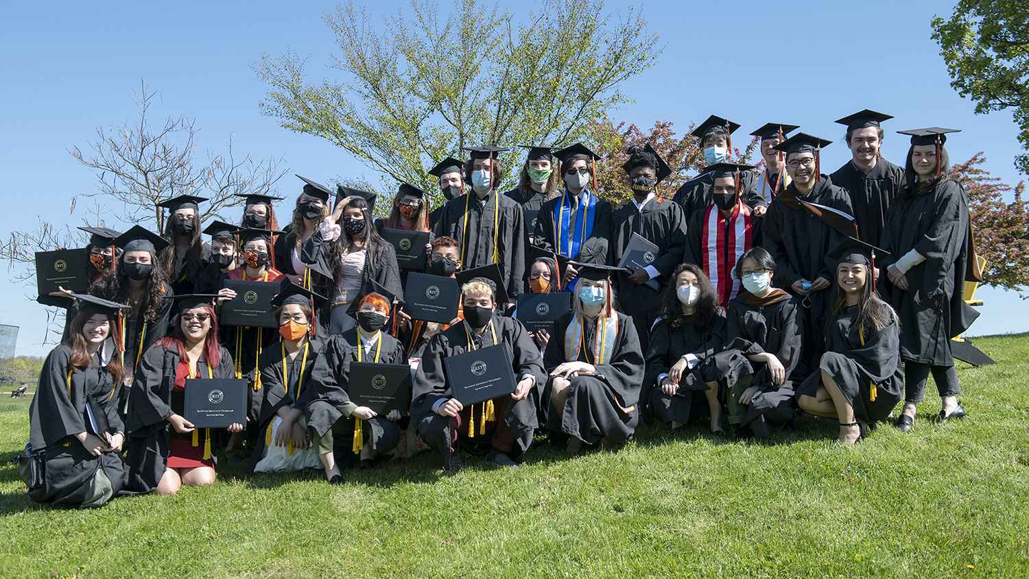 A large group of graduating students pose together in regalia.