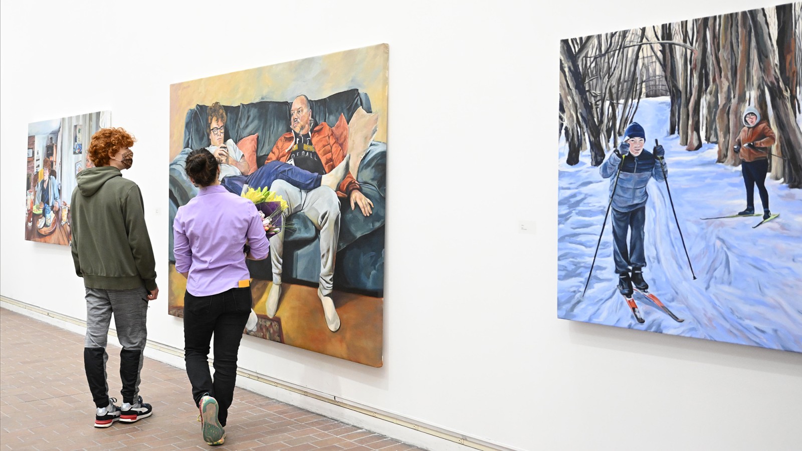 Gallery visitors look at wall paintings.