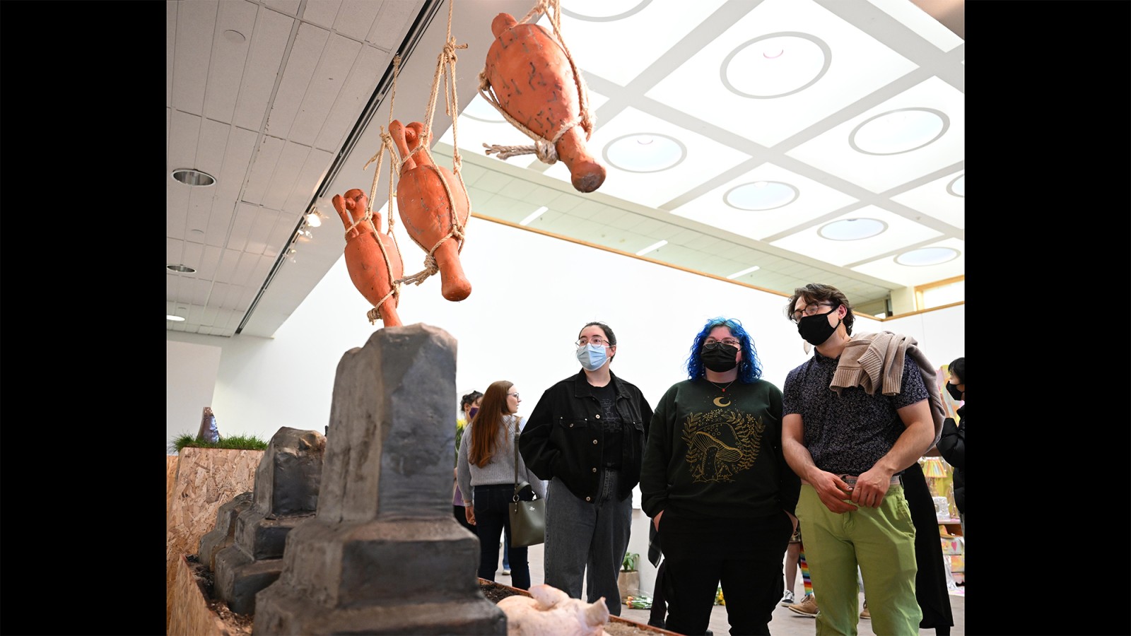 People look at ceramic sculptures.