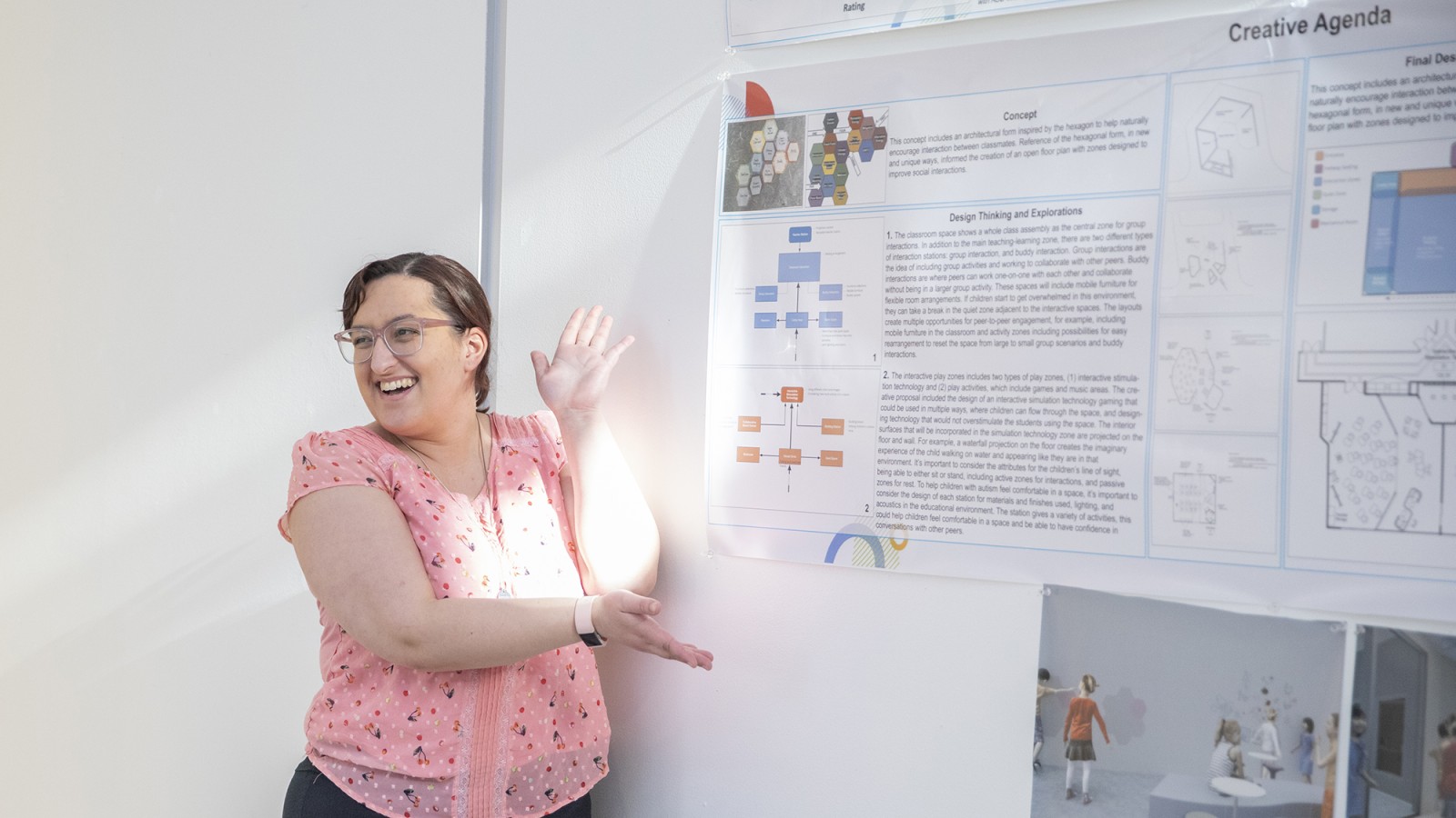 A student showcases her poster for her interior design BFA capstone project.