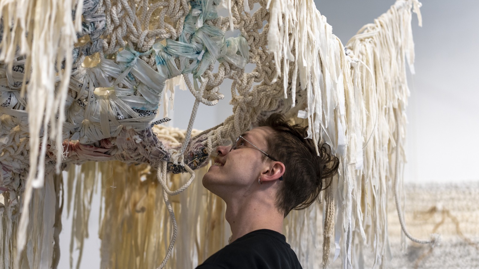 MFA student Alex Jarus looks at an installation hanging from the ceiling of RIT City Art Space.