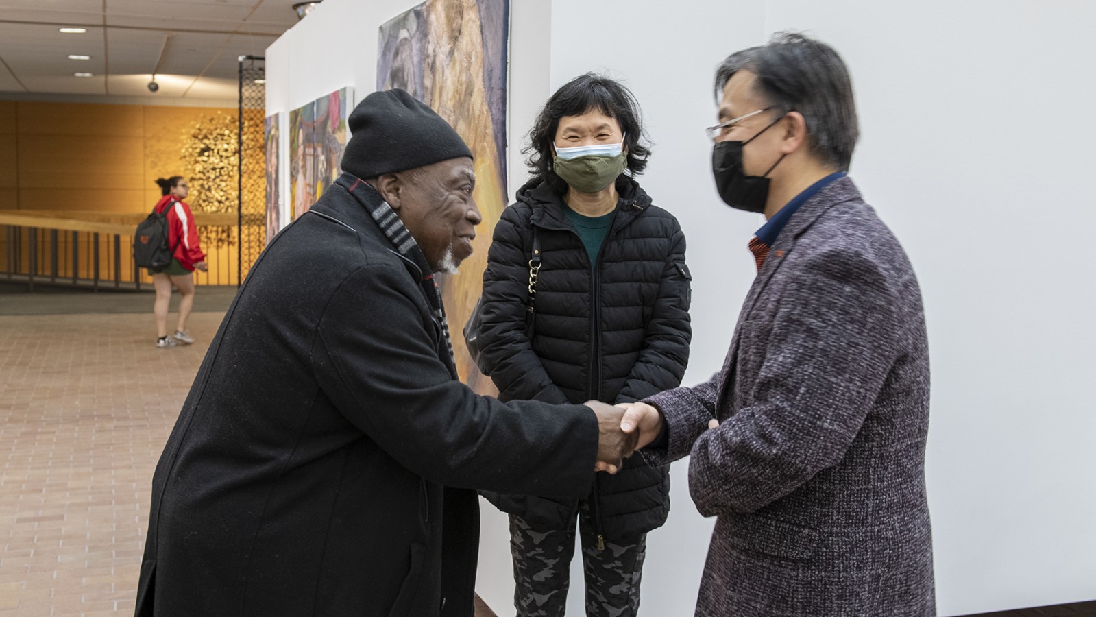Professor Luvon Sheppard shakes hands with someone in Bevier Gallery.