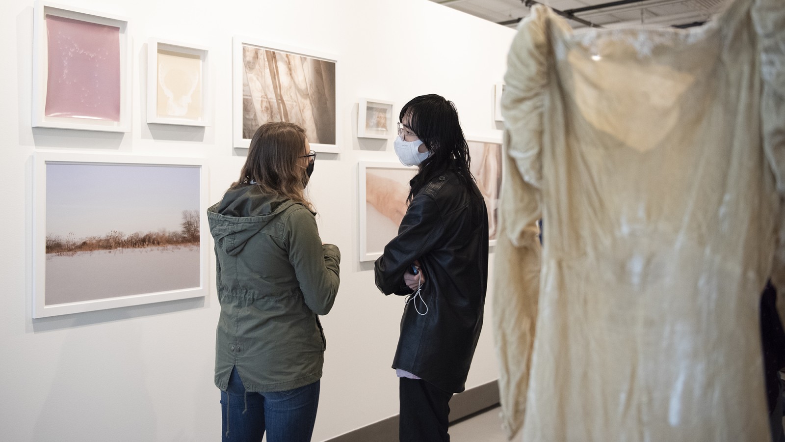 Two people talk in a gallery.