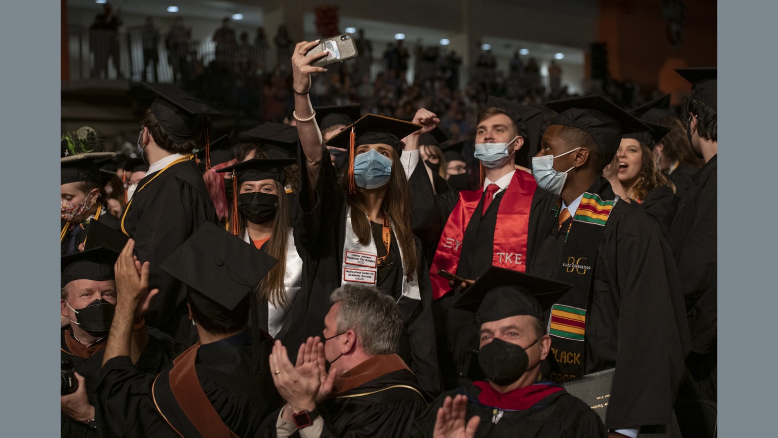 A group of students in the crowd takes a selfie.