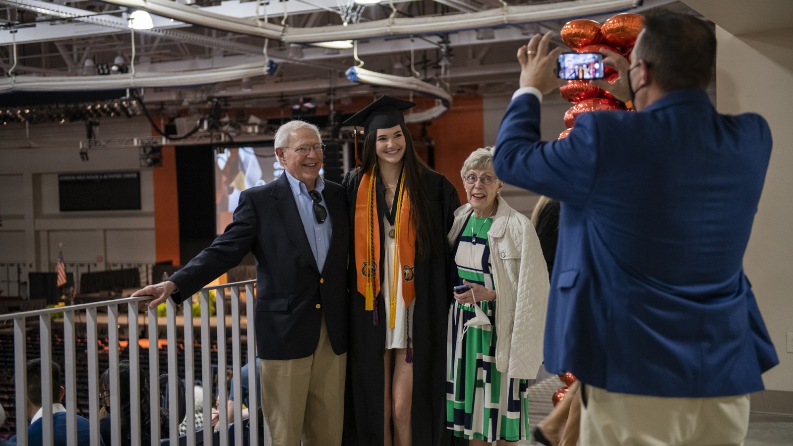 Someone takes a photo of a new grad and their family. 