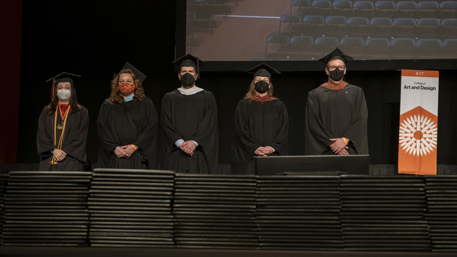 Faculty stand side by side.