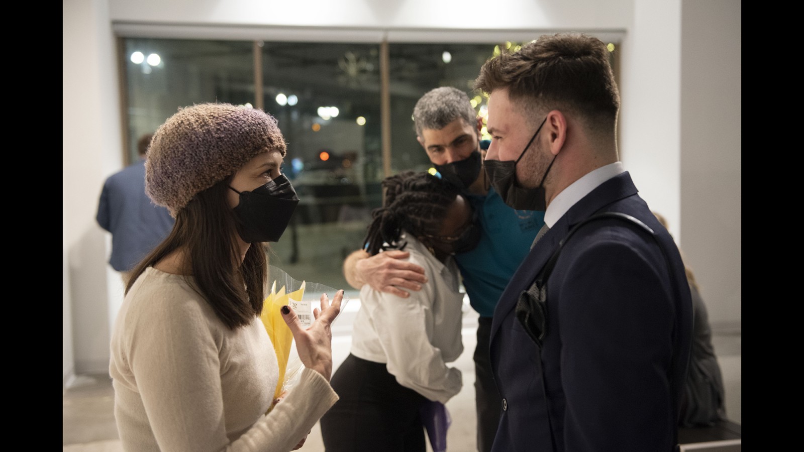 Faculty and students talk and embrace.