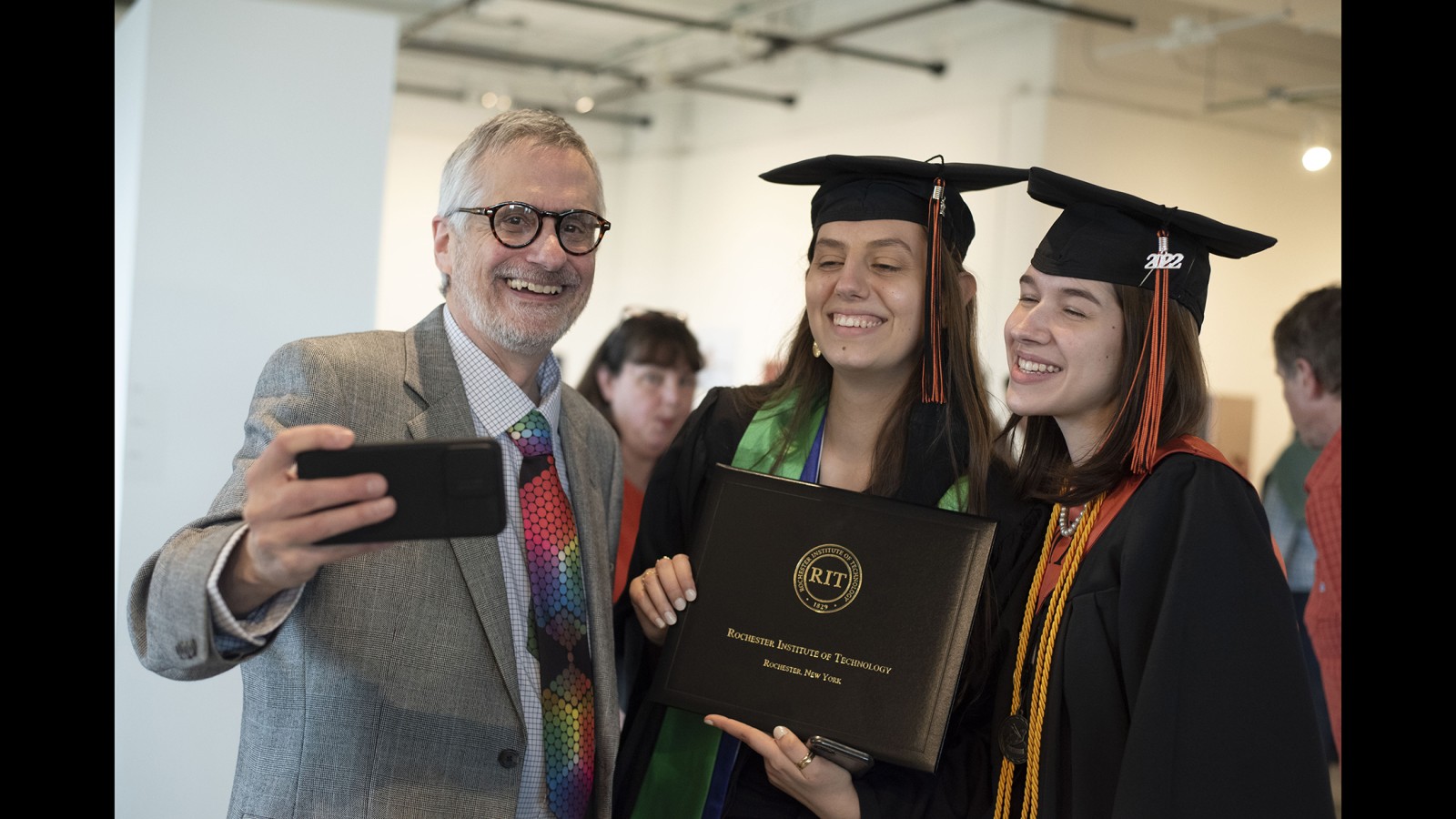 Frank Cost, faculty, with two new graduates.