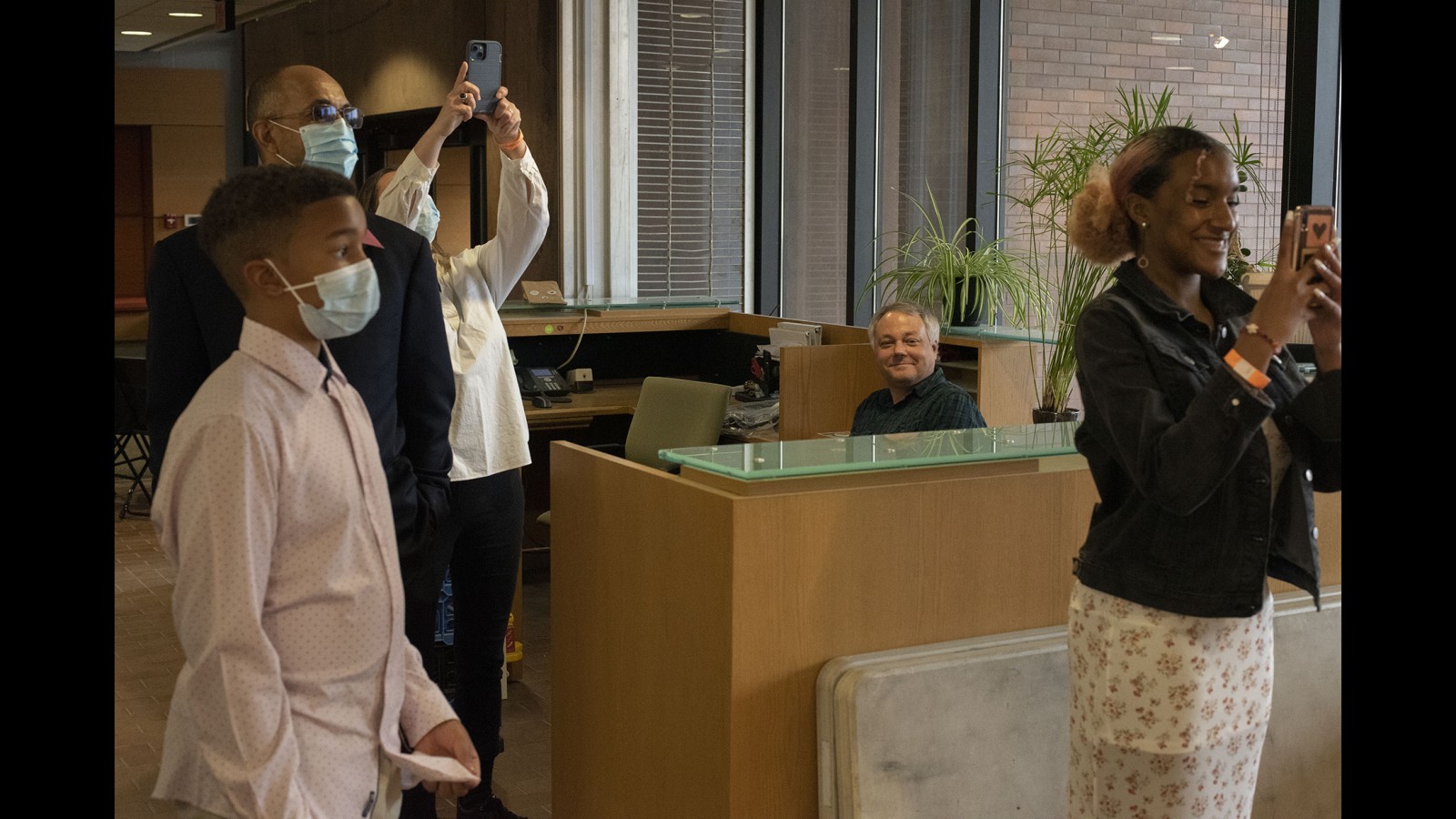 A family takes photos of their daughter.