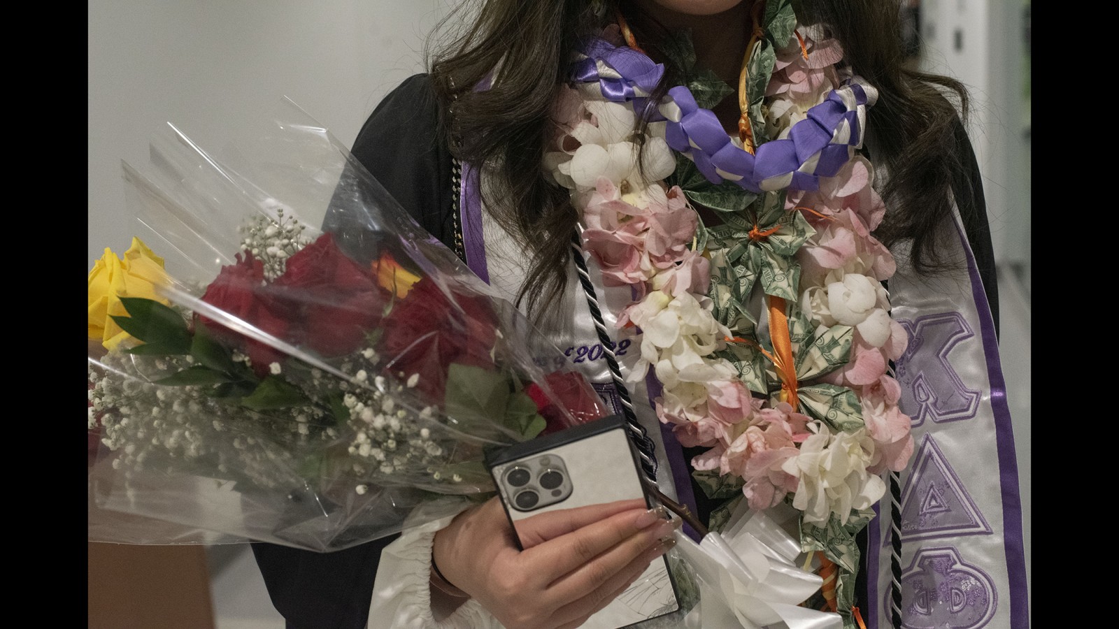 A detailed look at an ornamental necklace worn by a new graudate.