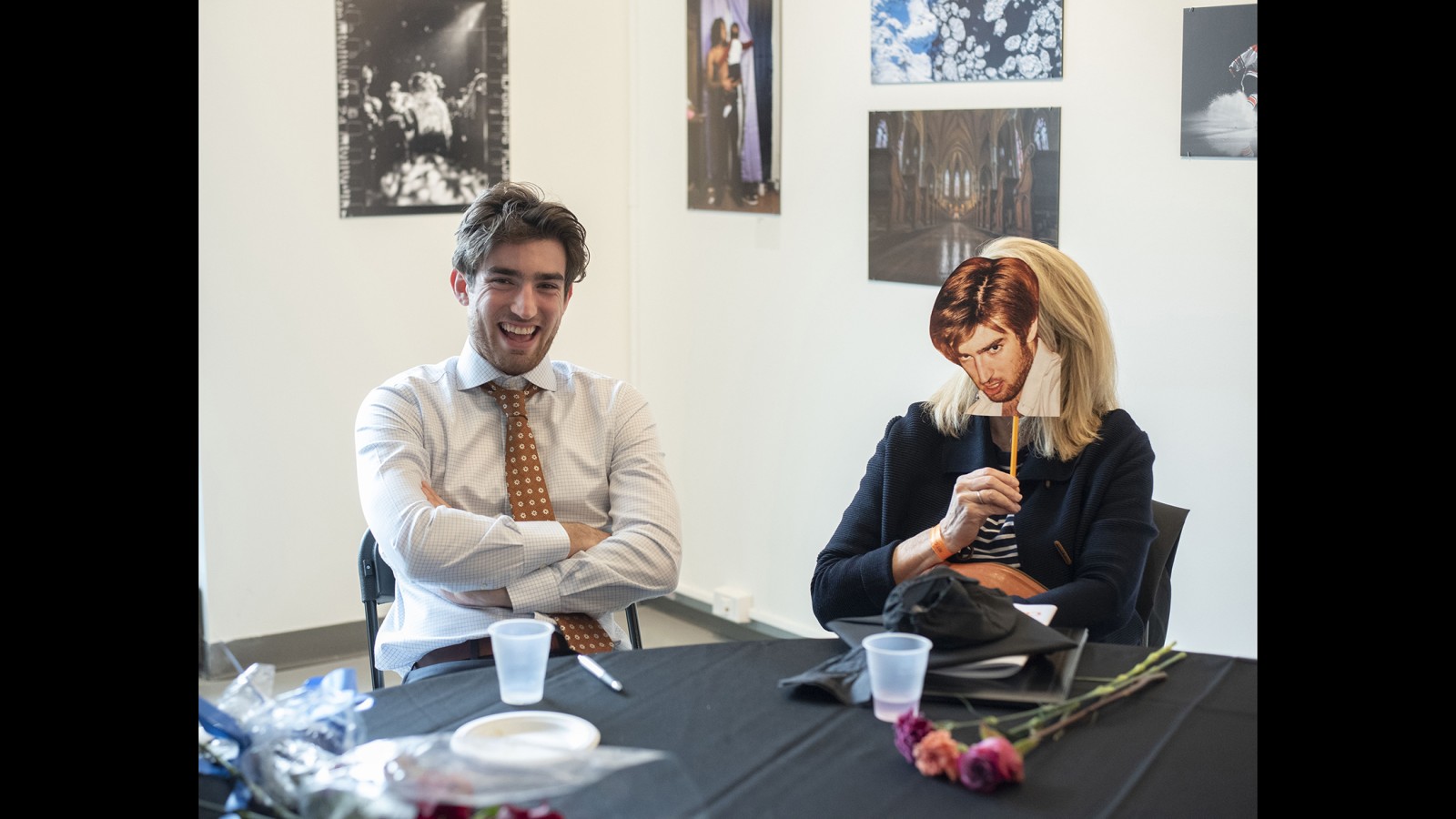 A new graduate sits at a table with his family.
