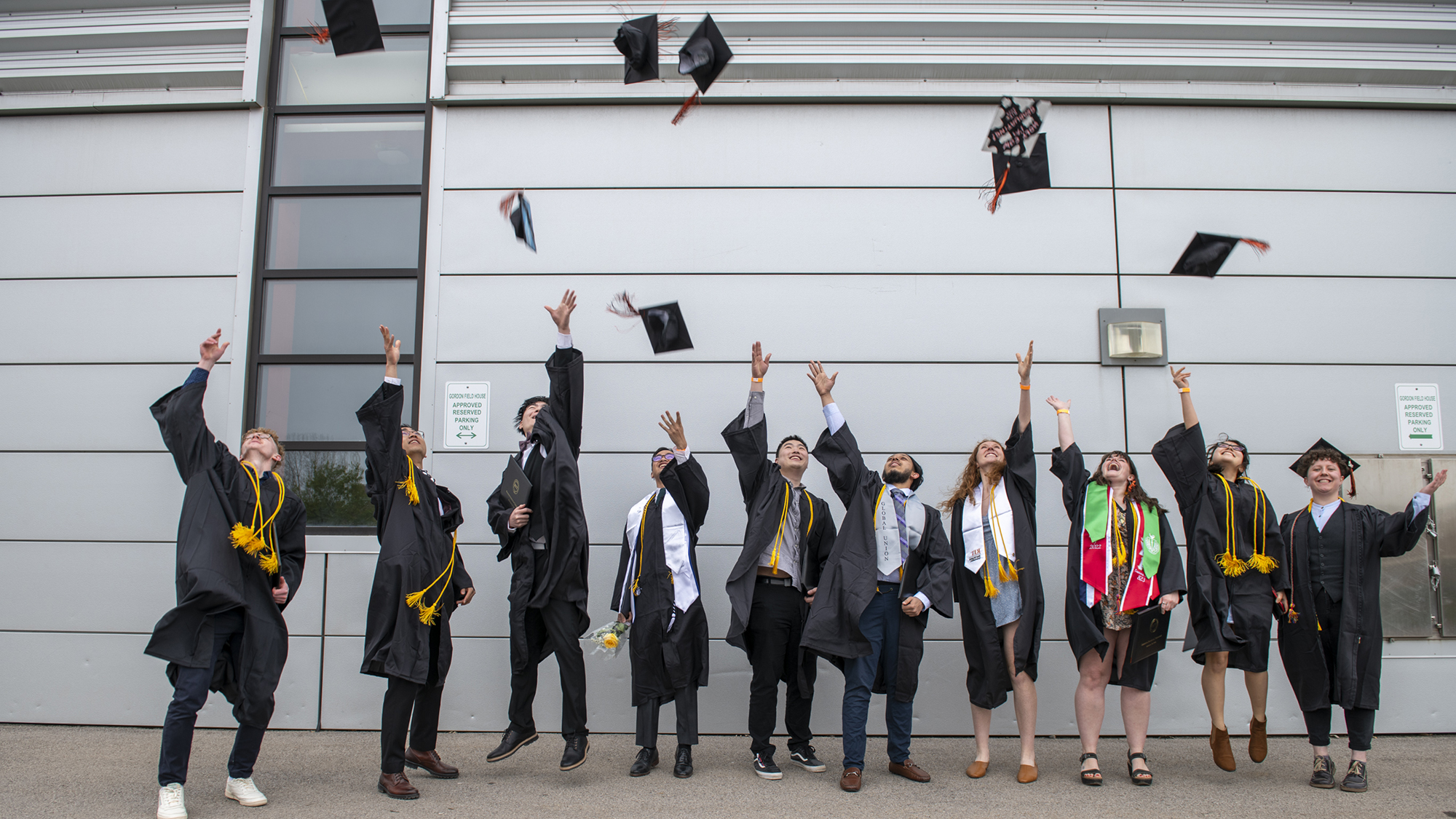 A group of student throw their graduation caps into the air.