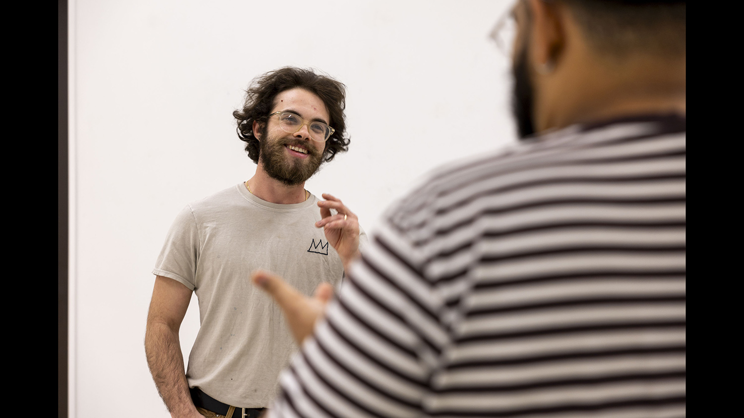 MFA candidate Jon Mills smiles and talks with visiting artist Corey Pemberton.