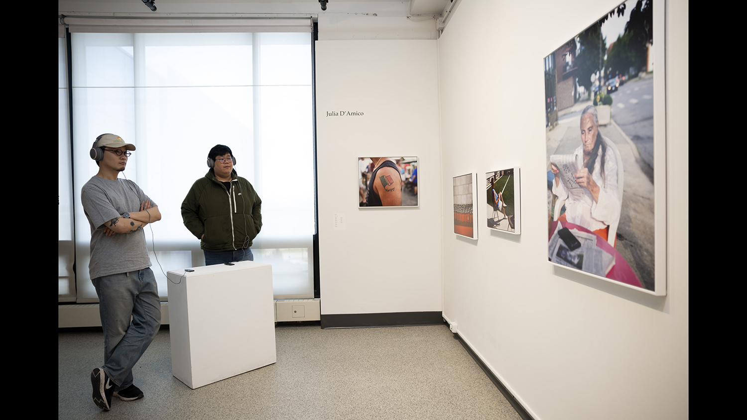 Two gallery visitors observe work on a gallery wall.