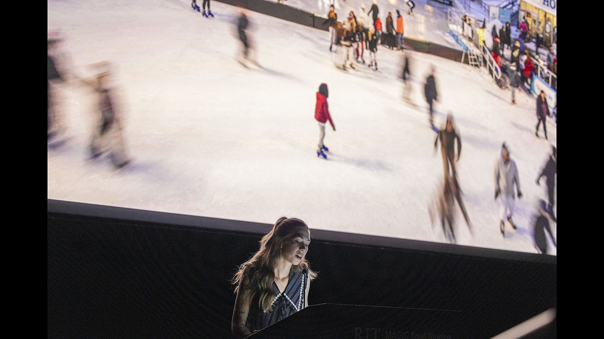 A student presents photos she took on a large projection screen.