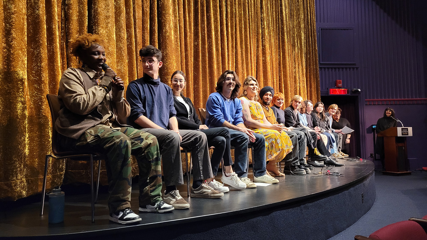 A lineup of RIT filmmakers sit on stage for a Q-and-A at Dryden Theatre.