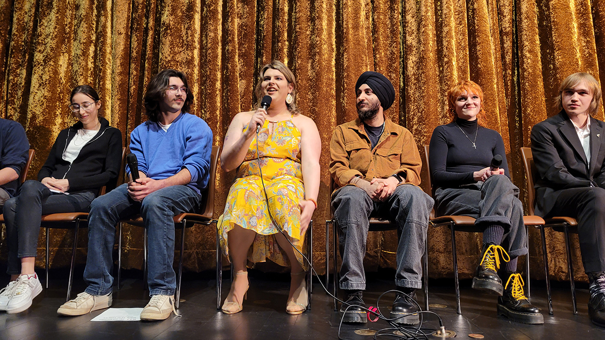 A lineup of RIT filmmakers sit on stage for a Q-and-A at Dryden Theatre.