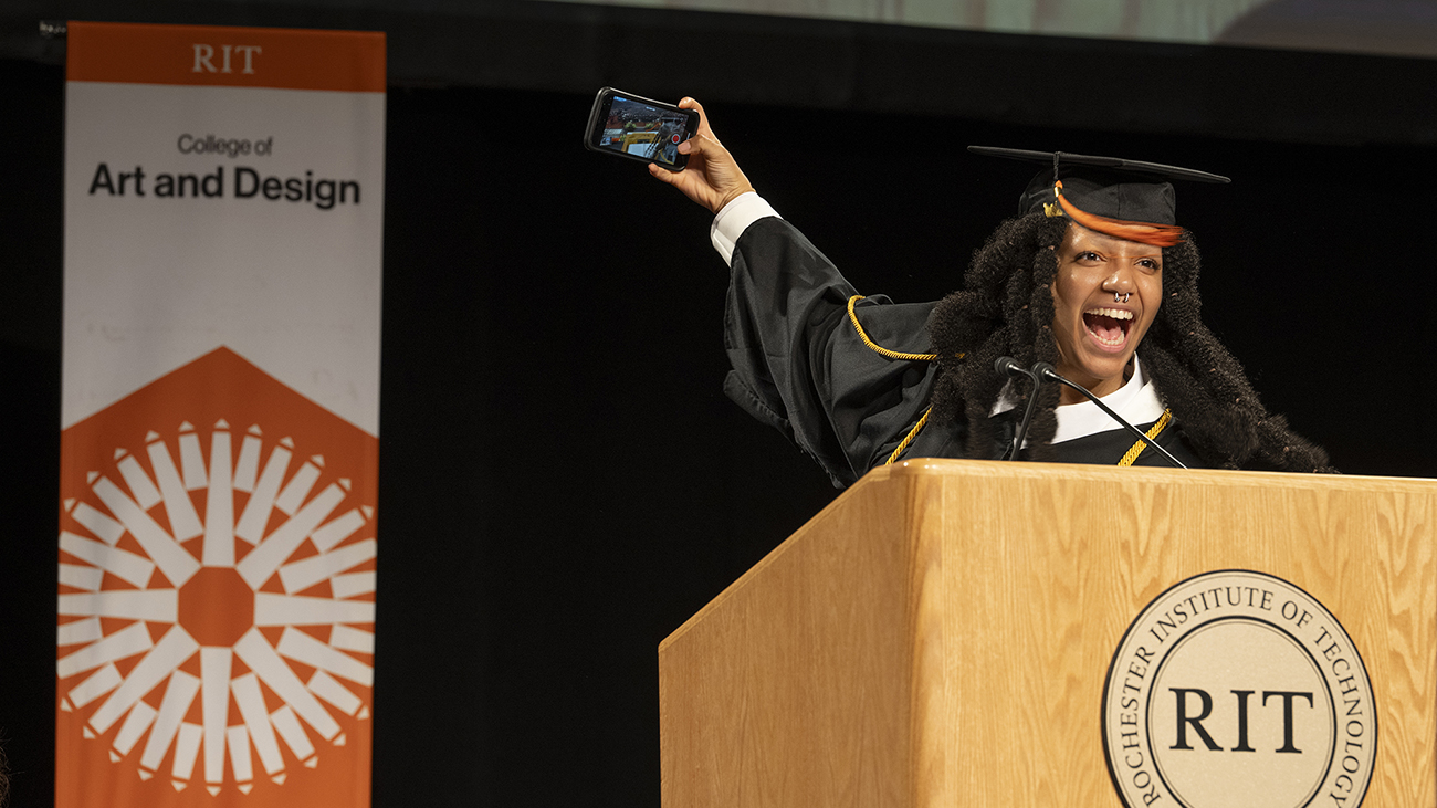 CAD's undergraduate delegate takes a selfie on stage.