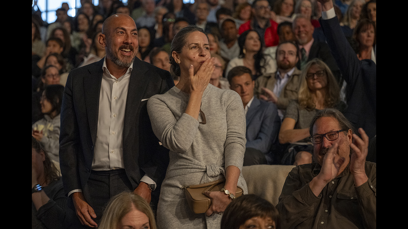Two people in the crowd blow kisses.