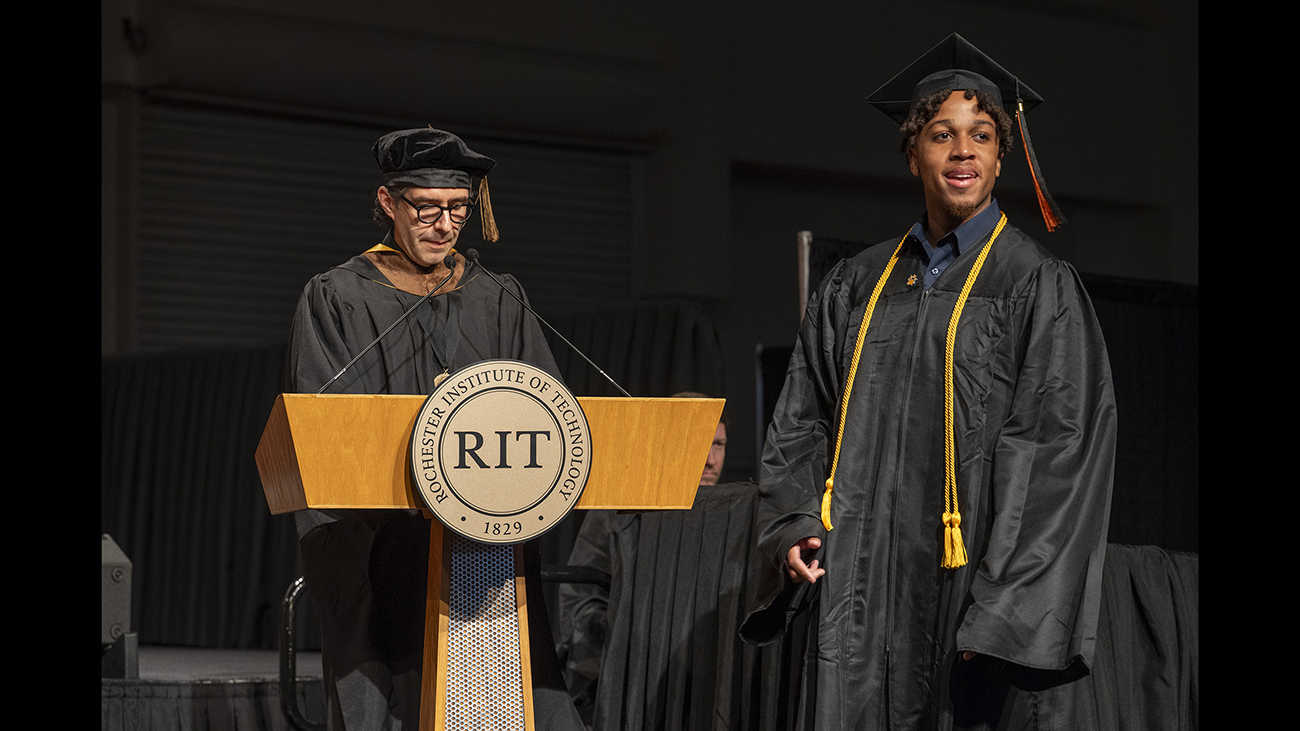 A student on stage during commencement.
