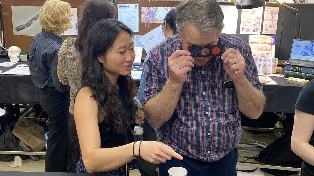 Glen Hintz looks at 3D glasses to view a student's medical illustration project.