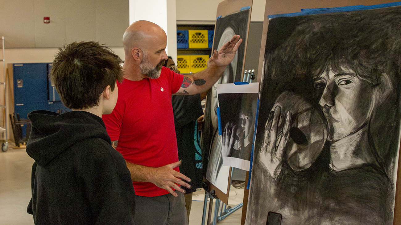 Faculty Denton Crawford instructs students as they draw in an RIT studio.