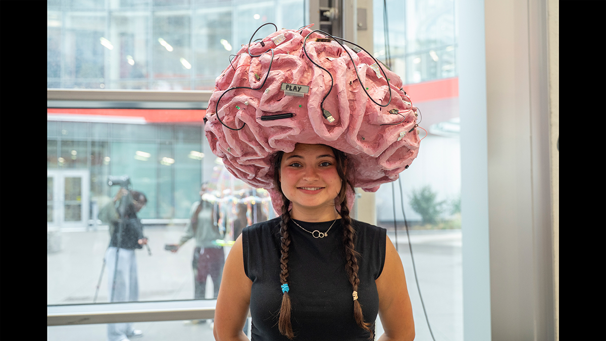 A student models a large brain they made out of various materials.