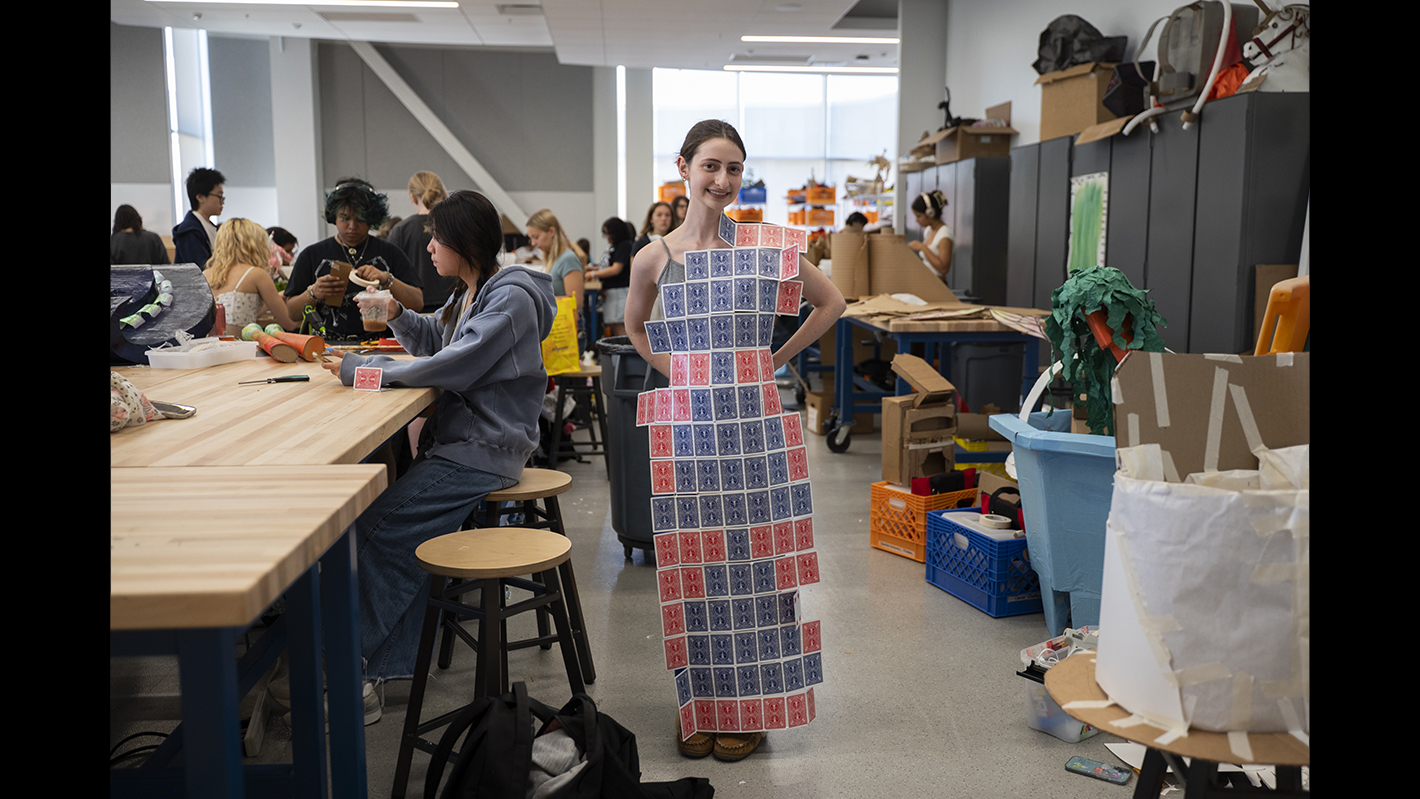 A student poses in a dress made of playing cards.