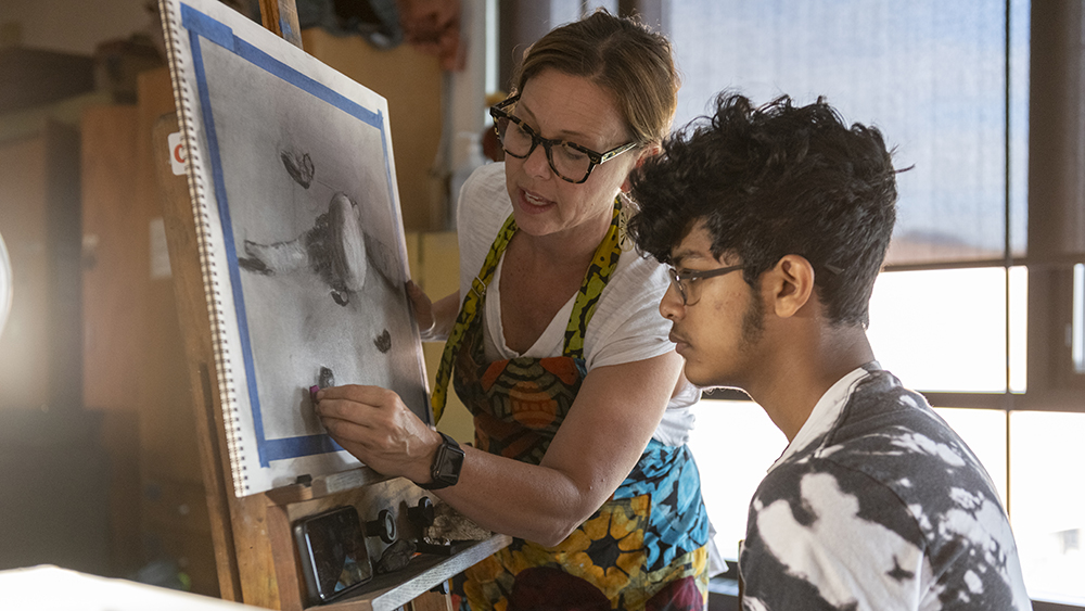 Faculty Amy McLaren does a drawing demo for a student.