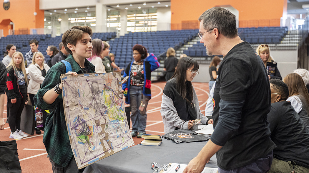 Faculty Allen Douglas looks at a piece of work by a prospective student.