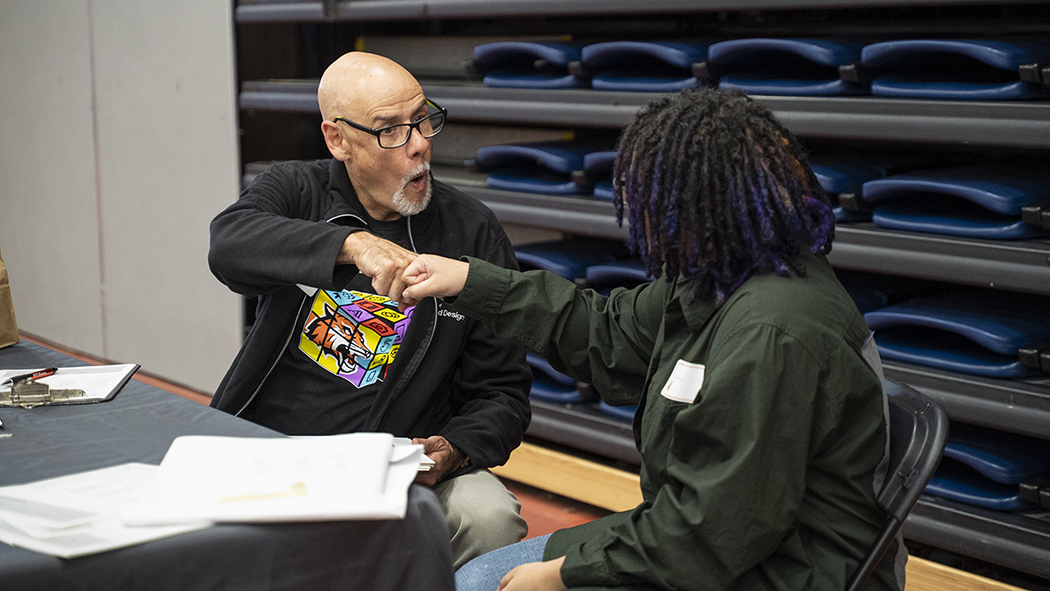 Faculty Jim Porto does "knucks" with a student.